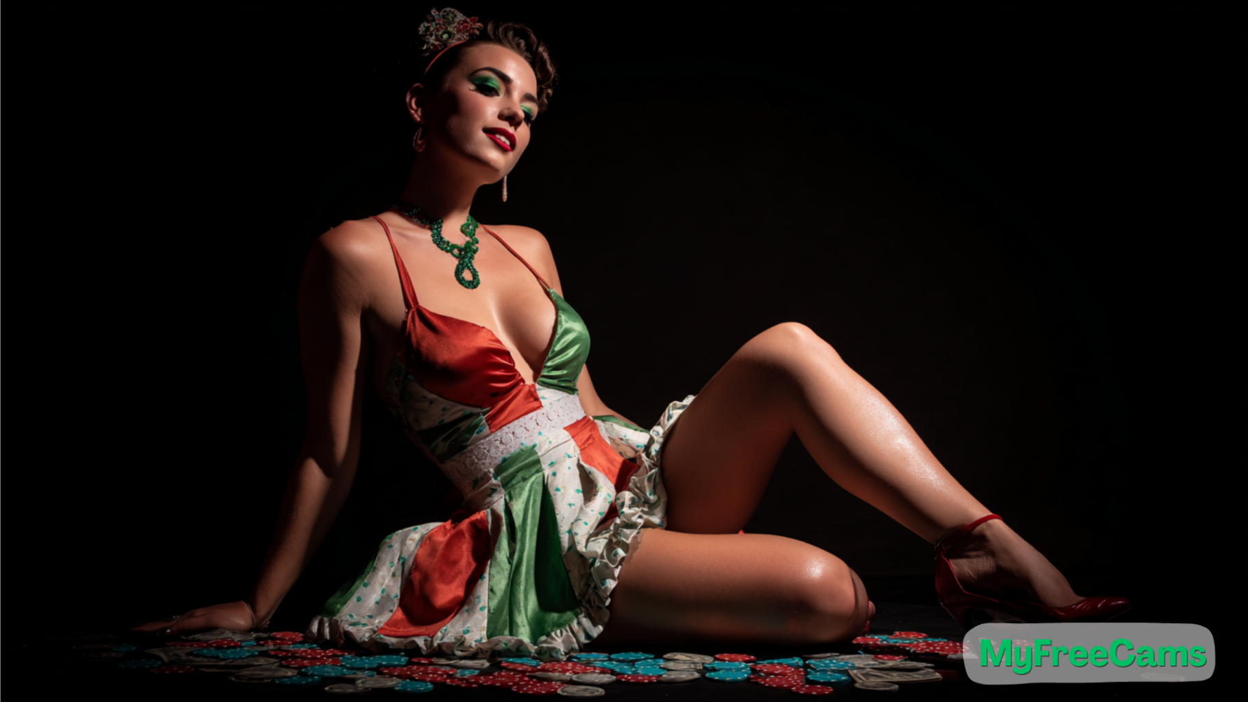 Femme maquillée avec des ombres à paupières vertes et un rouge à lèvres rouge, assise sur le sol dans une robe décolletée aux couleurs vives. Elle pose sous un éclairage tamisé, entourée de jetons de casino, dans une ambiance glamour inspirée des performances webcam pour adultes.